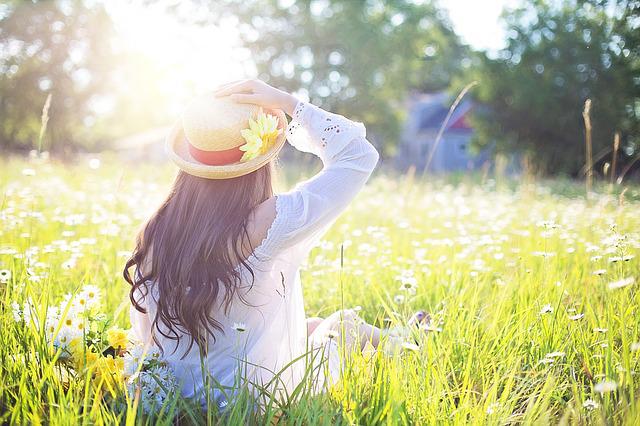 woman sitting in a flower field on a sunny day